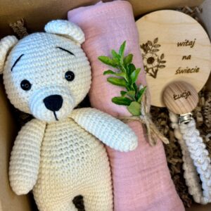 zestaw prezentowy Baby Box dla noworodka z misiem, zawieszką do smoczka i pieluszką.