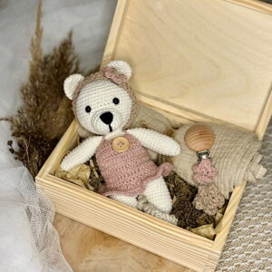 Zestaw dla noworodka w którym znajdziemy misia, zawieszkę oraz pieluszkę zapakowane w drewniane pudełko.