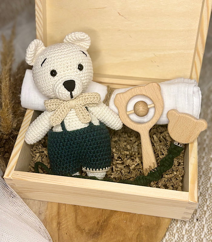 zestaw prezentowy dla noworodka skrzyneczka prezentowa z misiem, zawieszką, pieluszką i grzechotką.