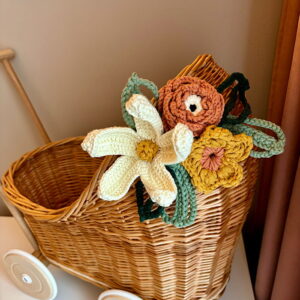 Wózek dla lalek z wikliny ozdobiony ręcznie wykonanymi kwiatami