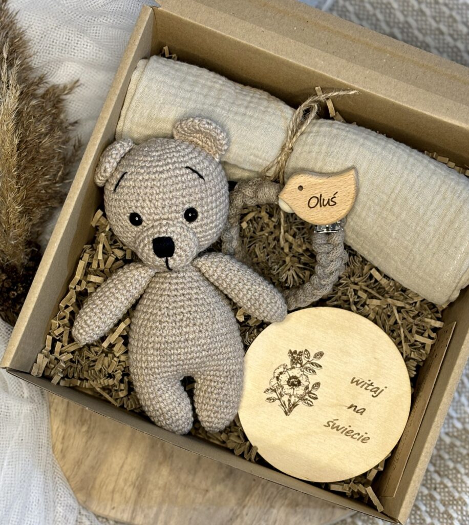 Baby Box zawierający misia, zawieszkę do smoczka oraz pieluszkę